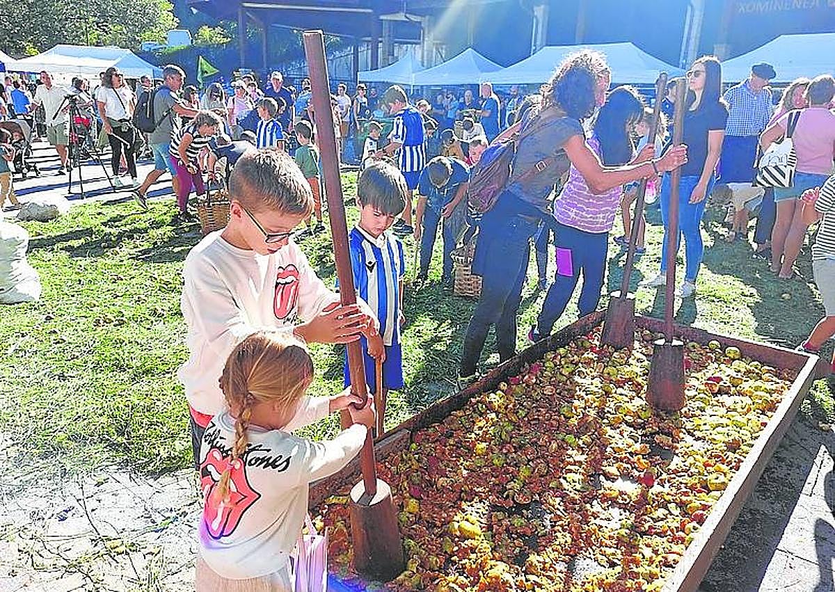 Imagen secundaria 1 - Dantzaris de Astigar bailaron la 'sagar dantza', los niños disfrutaron ayudando a elaborar el dulce clado y los asistentes probando el primer mosto. 