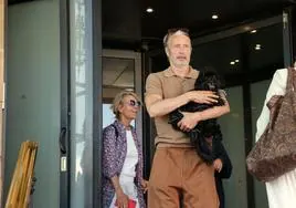 Mads Mikkelsen con su perro Messi en brazos y acompañado por su esposa Hanne saliendo del hotel María Cristina este lunes.