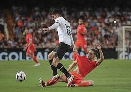 Beñat Turrientes disputa el balón a Özkacar en el encuentro de ayer ante el Valencia.