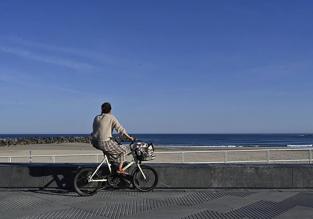 Una persona contempla la playa de Zurriola.