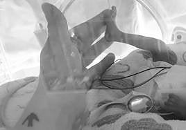 Eli' toca el pie de su bebé cuando la pequeña se encontraba en la incubadora.