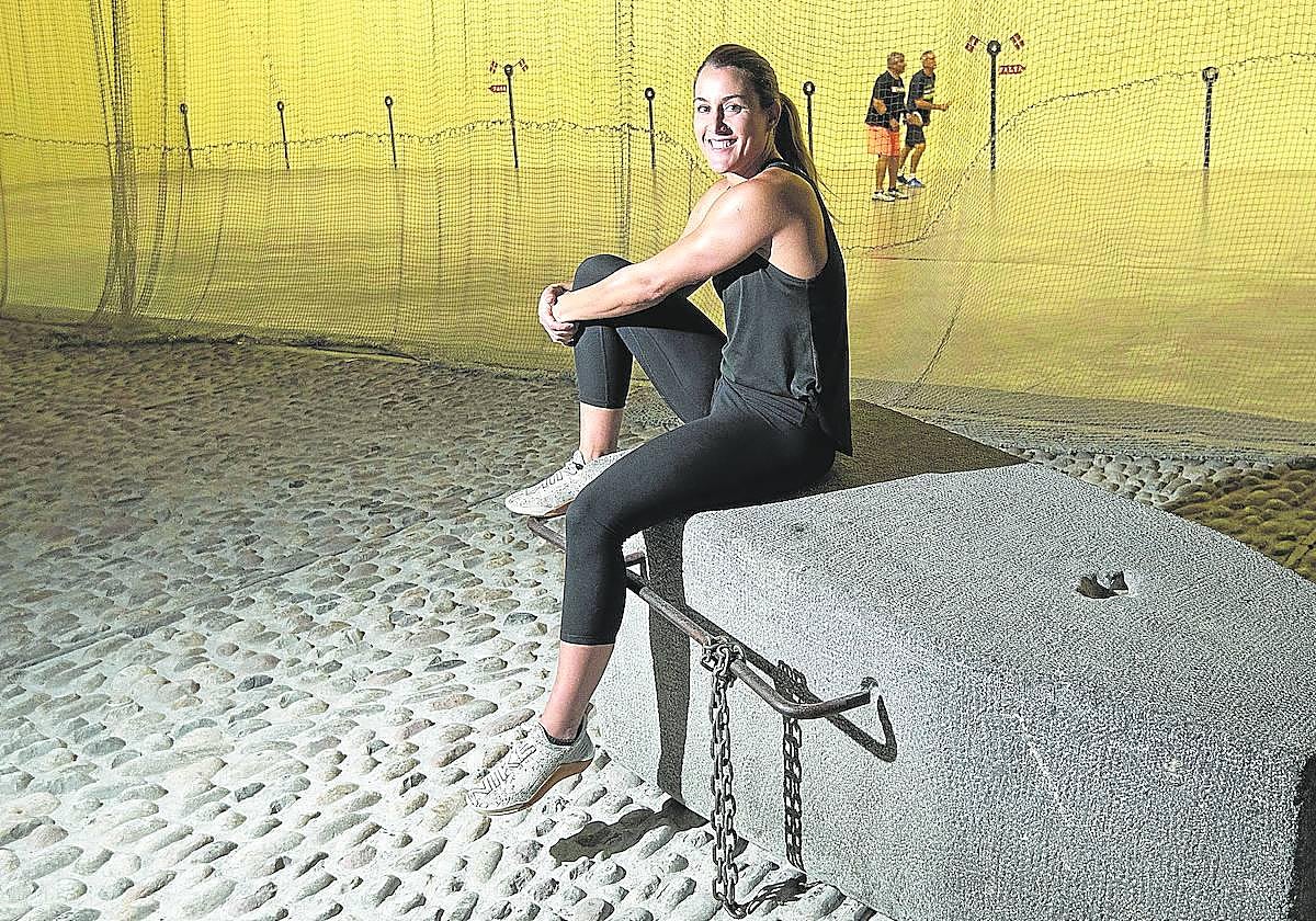 Nerea Arruti posa sonriente sentada en una piedra de arrastre de bueyes.