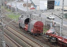 Las traviesas de madera destrozadas se aprecian bajo los vagones descarrilados.