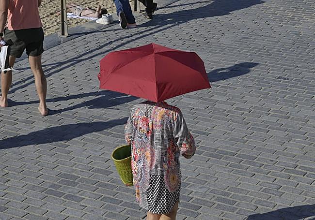 Una mujer abandona La Concha con su paraguas contra el bochorno el pasado 7 de octubre.