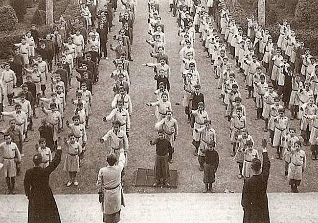 Alumnos de una escuela en la posguerra cantando el 'Cara al sol'.