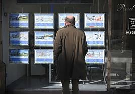 Un hombre observa el escaparate de una agencia inmobiliaria de San Sebastián.