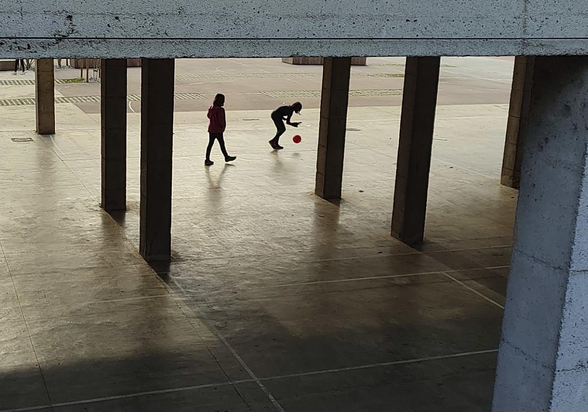Dos menores juegan en el patio de un centro escolar del municipio.