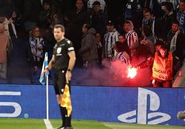 Un miembro de seguridad del campo retira una de las bengalas lanzadas a la grada familiar de Anoeta el pasado miércoles.
