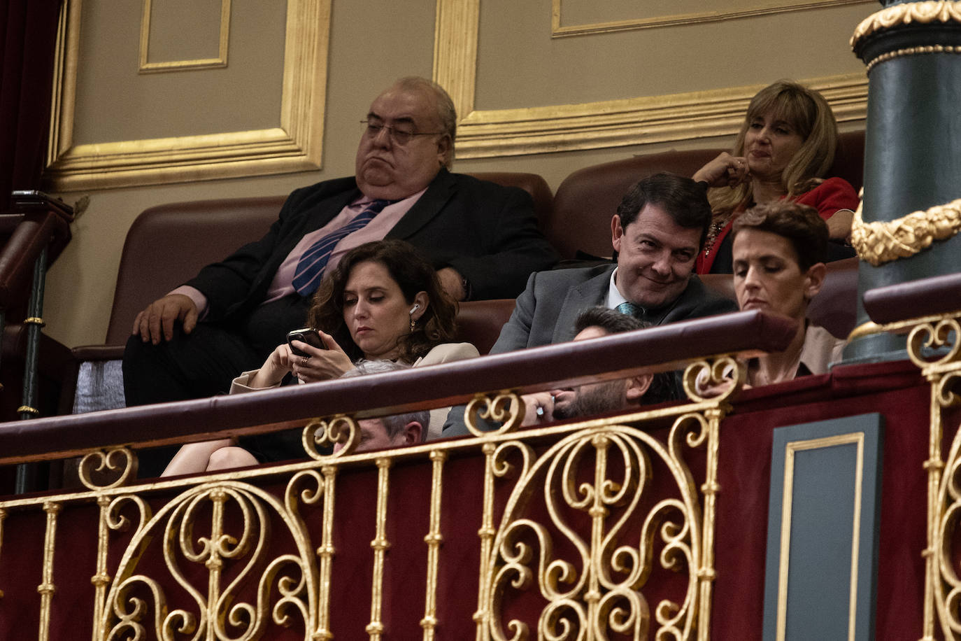 Isabel Díaz Ayuso mira su móvil en la tribuna de invitados del Congreso de los Diputados.