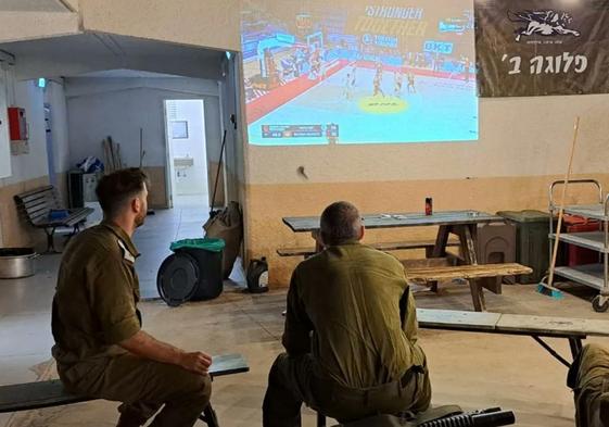 Dos soldados,viendo al Maccabi.