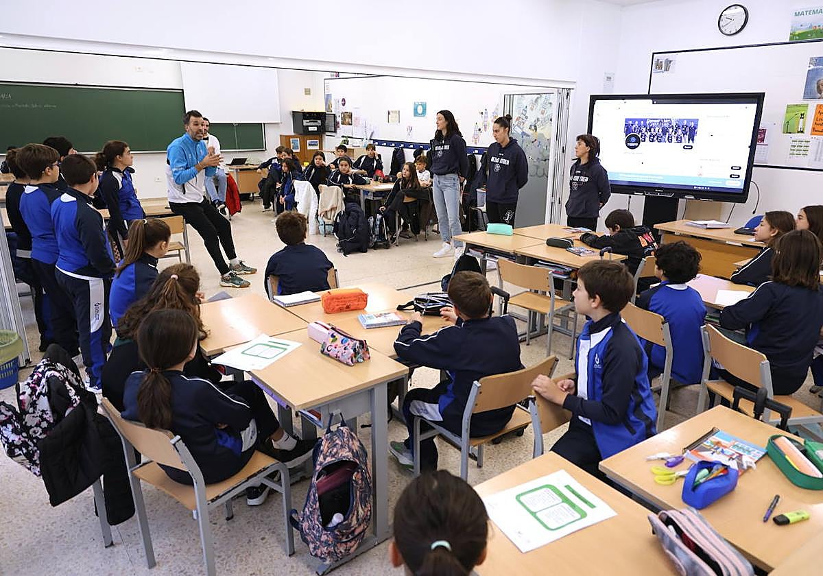 Jon Santamaría se dirige a los escolares en la visita del IDK Euskotren a la ikastola Ekintza en Donostia, ante la mirada de las jugadoras Gracia Alonso y Lara González y la entrenadora, Azu Muguruza.