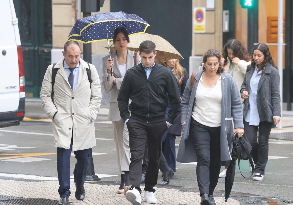 El abogado de la familia de Santi Coca, Eduardo Ruiz de Erenchun, camina hacia una de las sesiones del juicio junto al hermano y la madre del joven, Iker y Fátima Hacine-Bacha.