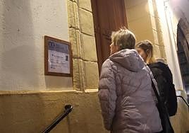 Unas vecinas miran la esquela de Iñaki G.V., uno de los dos jóvenes fallecidos, en la parroquia San Fermín de Pasai Antxo.