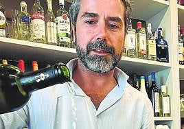 Juan Palomo sirve una copa de vino en su restaurante sevillano.