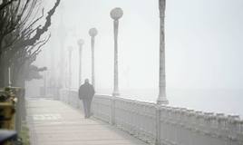 Una persona camina entre la niebla en San Sebastián.