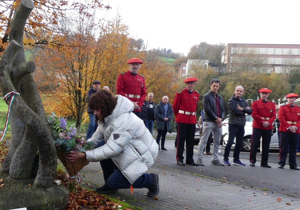 Victoria Landa coloca un ramo de flores en el monolito ubicado en el exterior de la Ertzainetxea de Beasain.