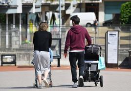Una pareja pasea con sus hijos pequeños por Donostia.