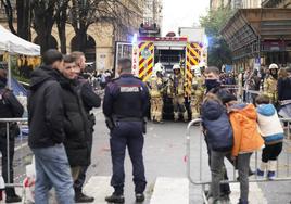 Bomberos, agentes y curiosos delante del puesto incendiado en la plaza de Gipuzkoa.