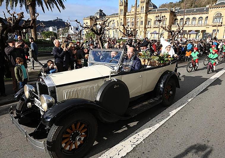 Olentzero y Mari Domingi recorren algunas calles de Donostia montados en un coche antiguo.