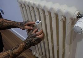 Un instalador coloca un contador individual en una vivienda con calefacción central.