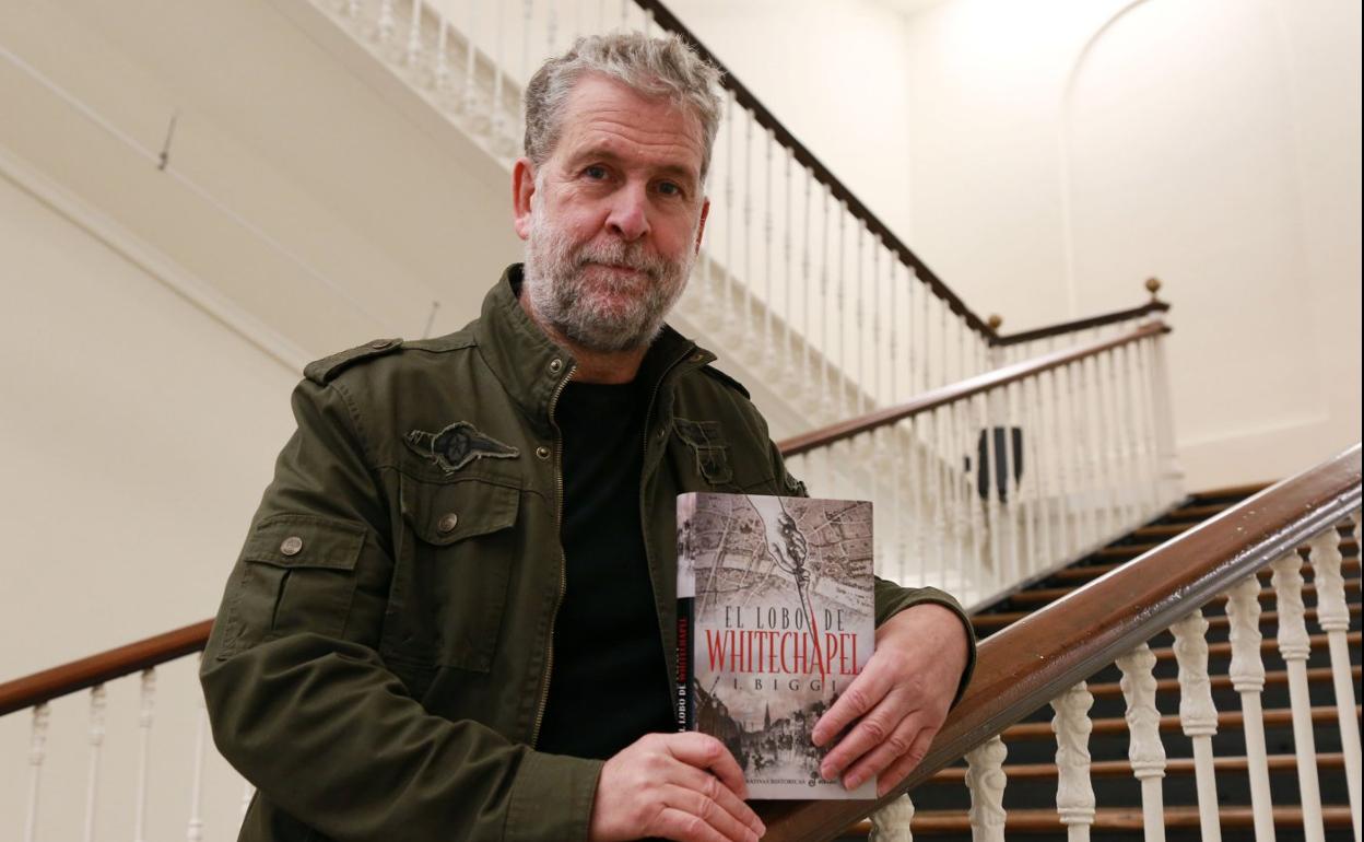 Iñaki Biggi sostiene un ejemplar de su última novela en la escalera de Tabakalera. 