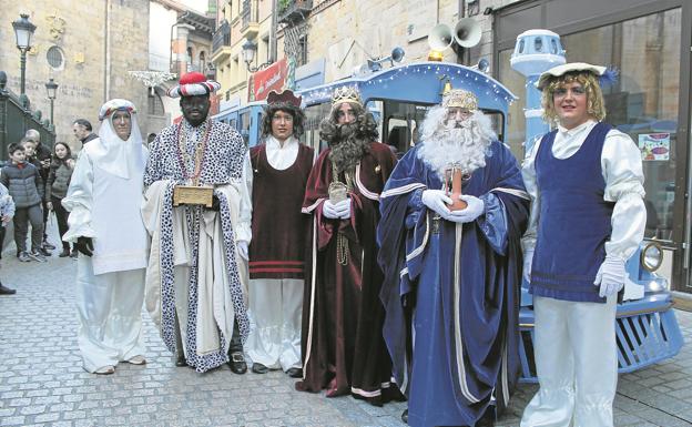 Imagen principal - Los tres Reyes Magos con sus pajes, repartiendo caramelos a los niños y Baltasar saluda antes de sufrir la caída desde su carroza.