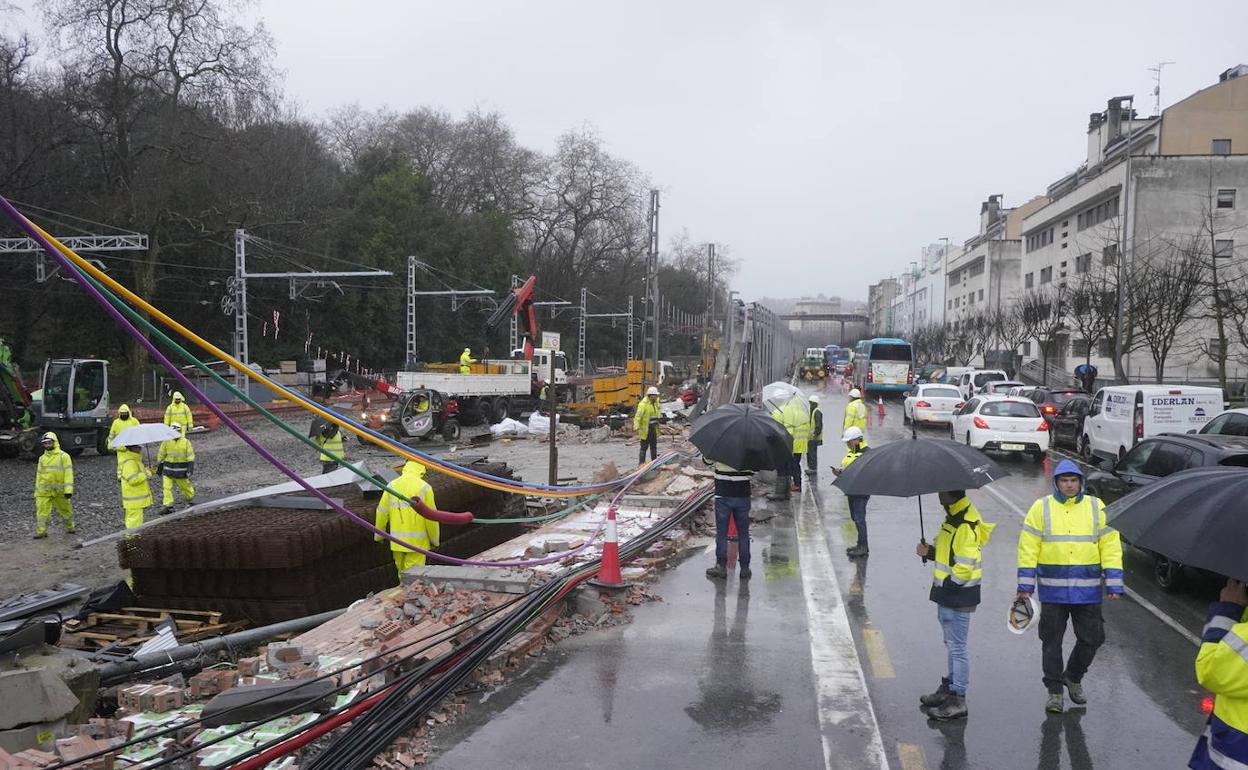 El muro que se ha desplomado en la calle Federico García Lorca de Donostia y operarios trabajando en la zona.