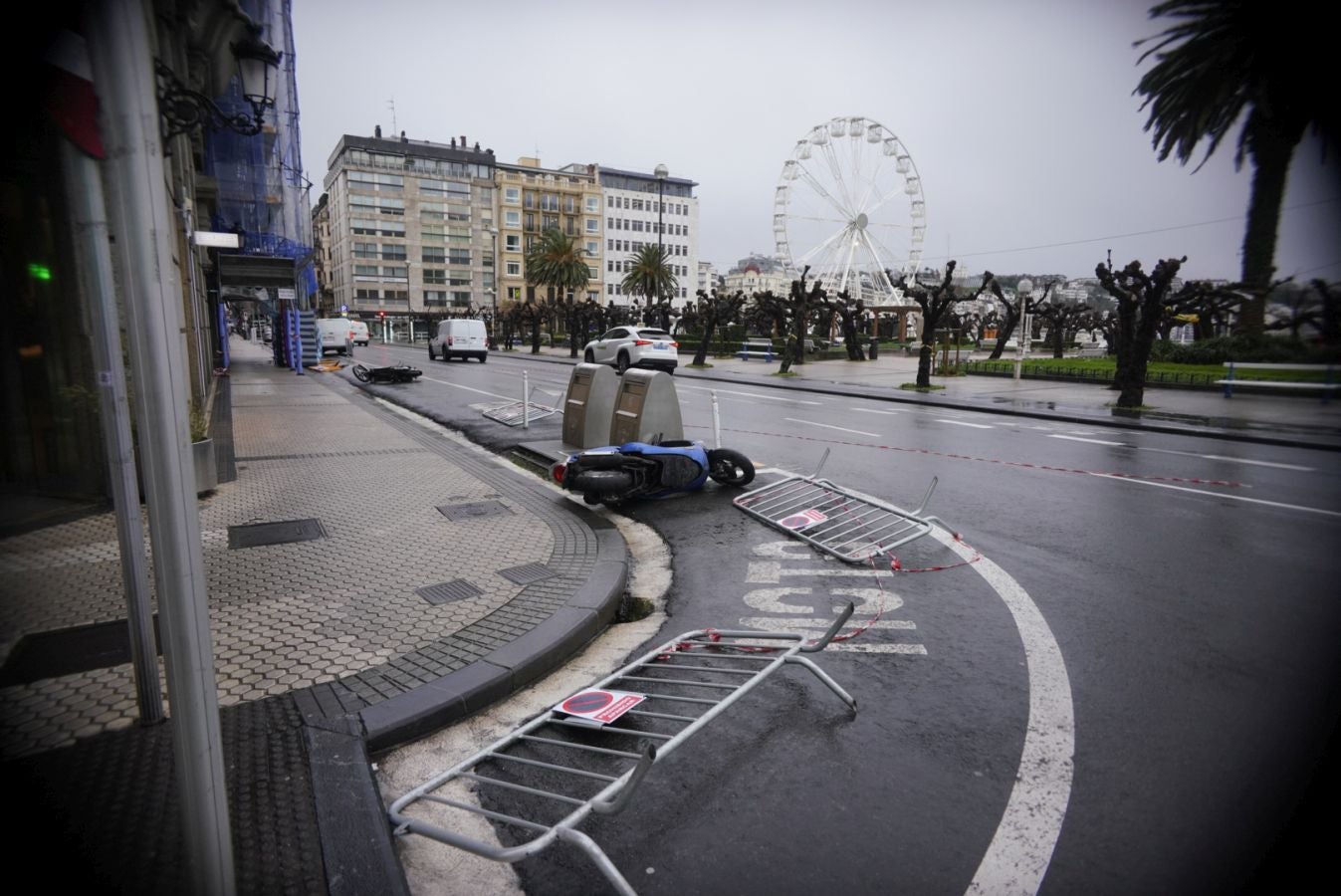 Motos y vallas caídas por el viento en el centro de San Sebastián