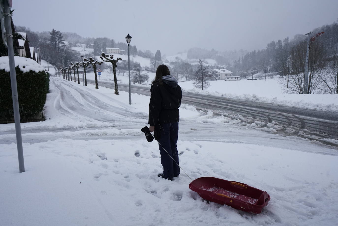 Una joven, con su trineo, en Bidania
