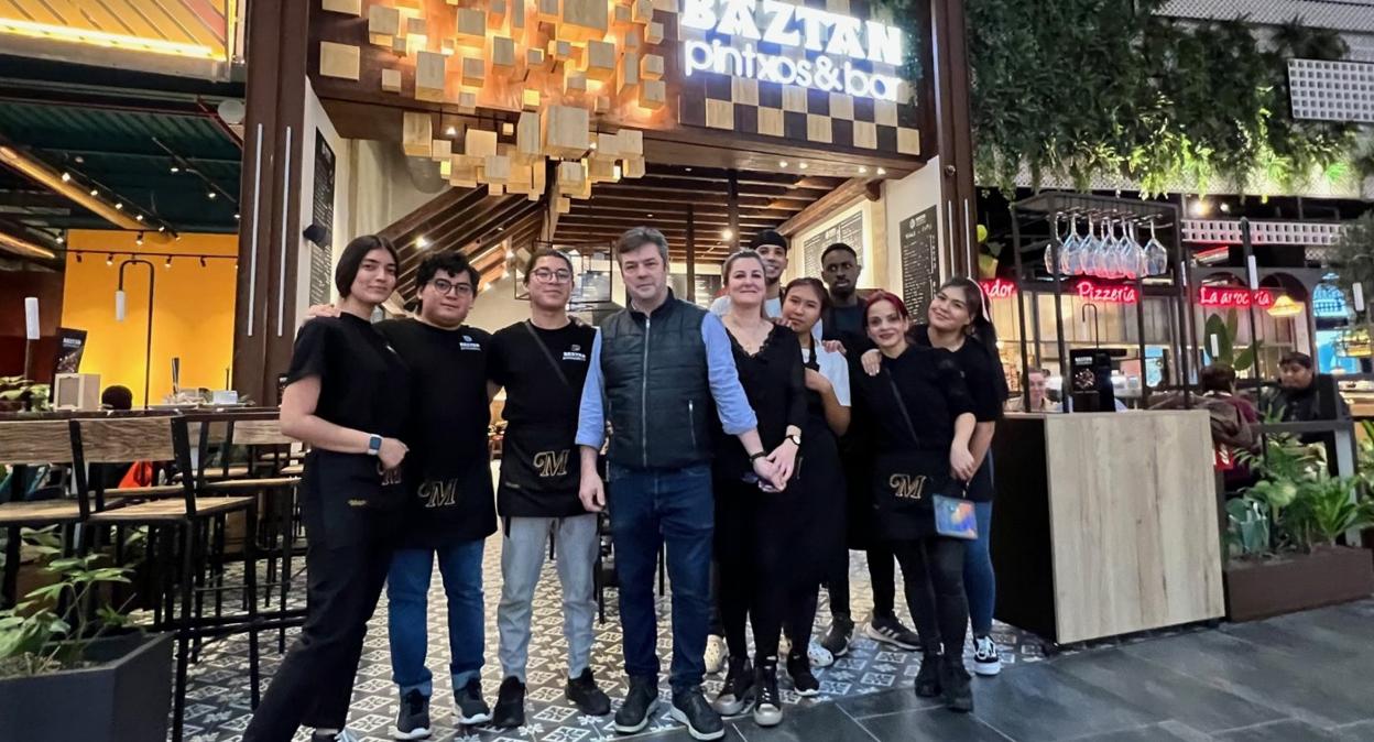 Aitor Oyarzabal y su esposa, Arantxa Ciaurriz, en el centro con los trabajadores del bar Baztán en Centro Comercial Garbera.