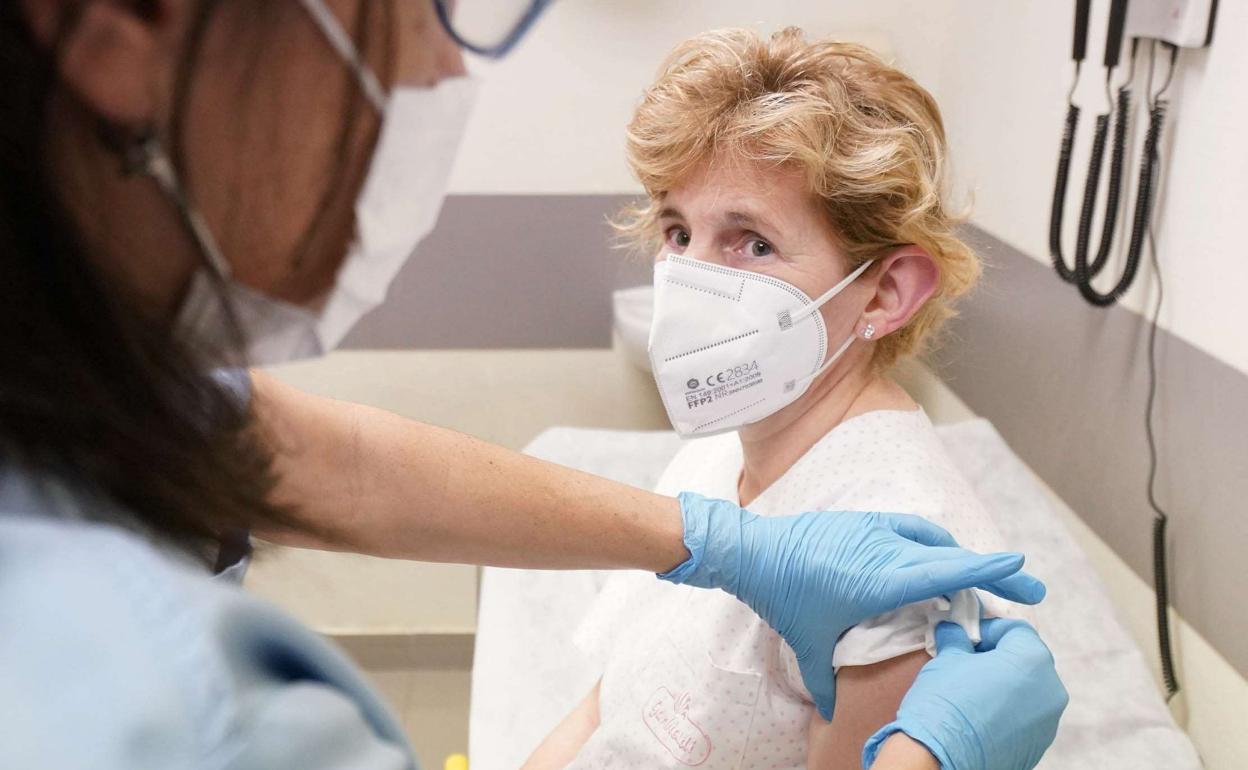Una enfermera vacuna a una mujer en el Hospital Donostia. 