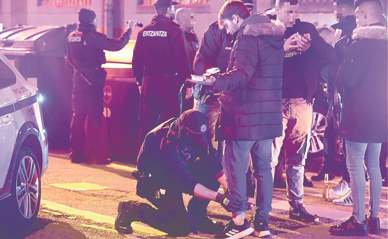 Un agente de la Ertzaintza cachea a un joven que se dispone a entrar en una discoteca. 