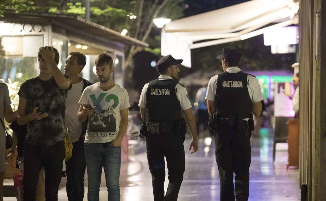 Varios policías municipales de Donostia, patrullando de noche las zonas de ocio de la ciudad.
