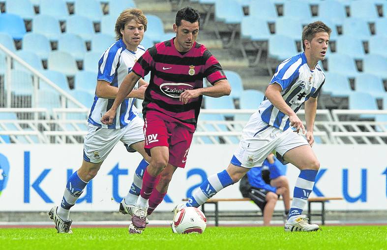 Gorka Brit conduce el balón con Illarramendi y Gaztañaga a su espalda en el derbi disputado en Anoeta en la temporada 2010/11. 