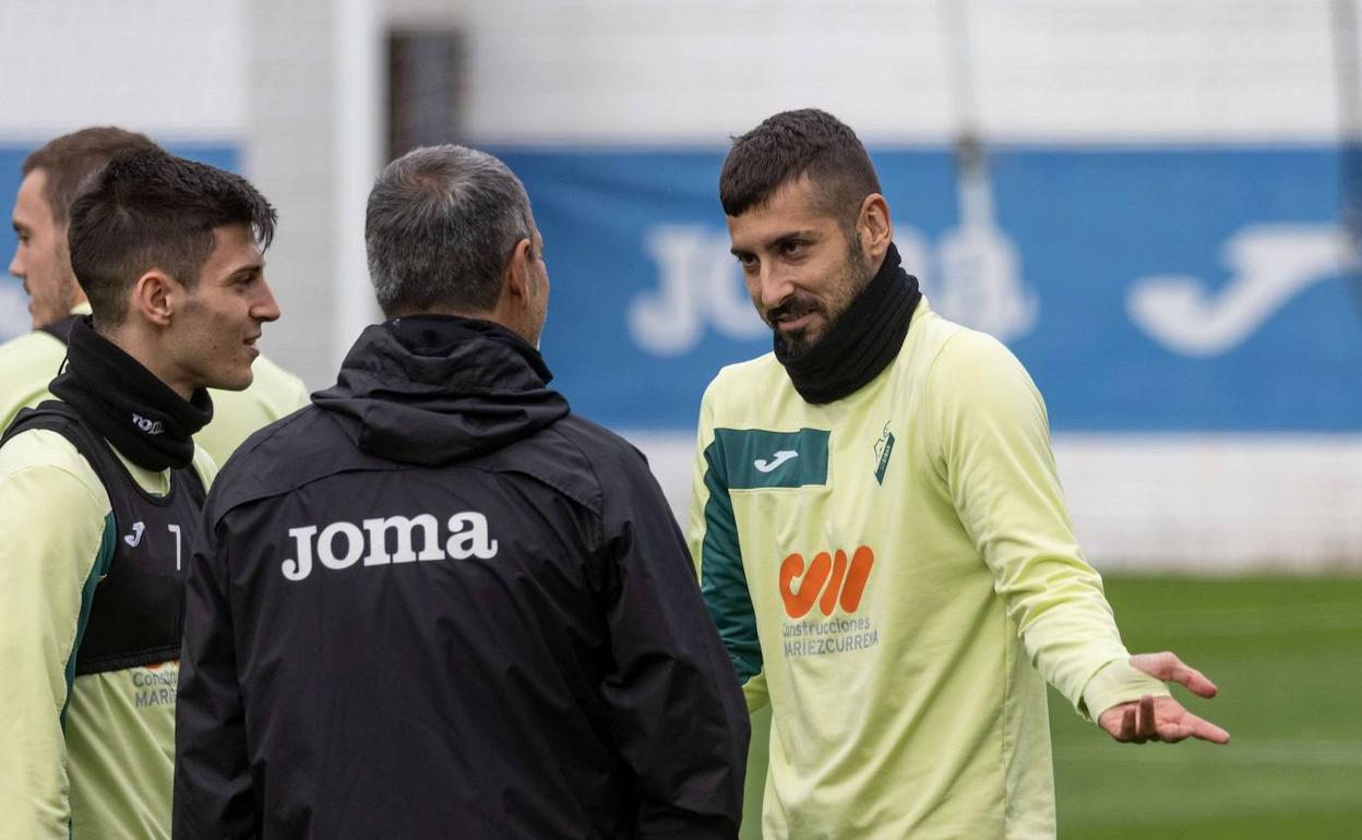 Vadillo charlando con Garitano ante la atenta mirada de Imanol.