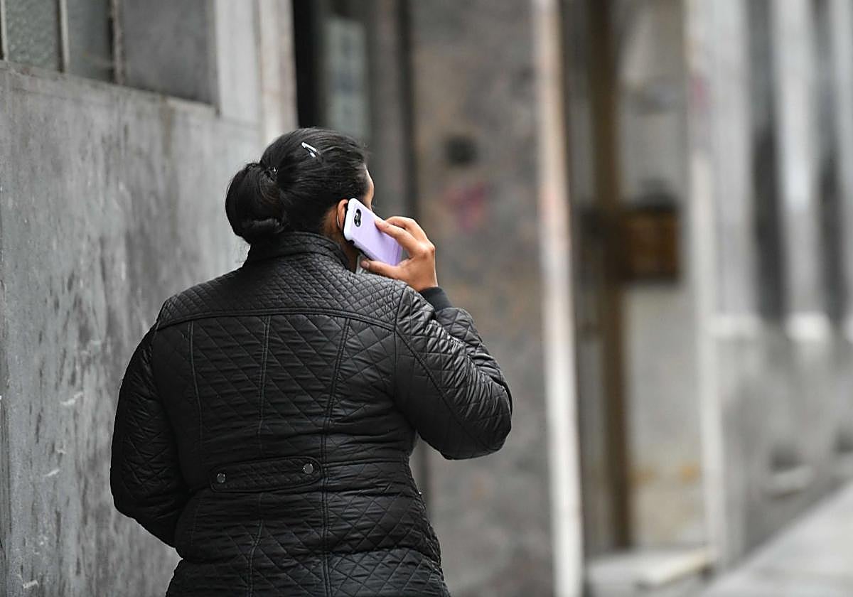 Una mujer habla por su teléfono móvil mientras pasea por la calle en Donostia.