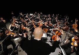 El director Unai Urrecho, de espaldas, dirige a la orquesta desde el escenario del Victoria Eugenia.