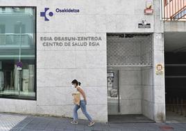 Una mujer con mascarilla pasa por delante del centro de salud de Egia, en Donostia.