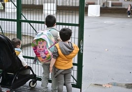 Varios niños pequeños miran hacia el patio de un colegio de Donostia.