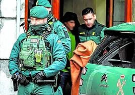 Agentes de la Guardia Civil con el detenido este lunes en Romo, tras finalizar el registro de la vivienda.