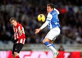 Elustondo trata de interceptar un balón ante la mirada de Munian en un derbi disputado en Anoeta.