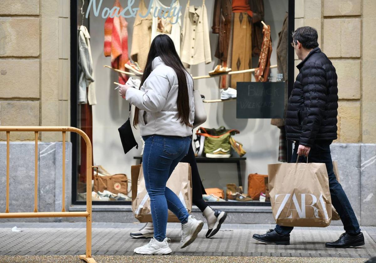 Joven mujer positiva comprando ropa deportiva en la sección de