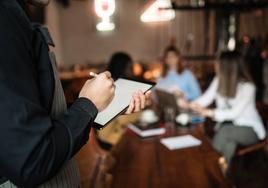 Un camarero toma notas dentro de un restaurante.