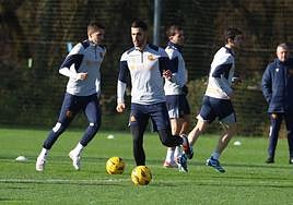 Merino, bien abrigado en el entrenamiento de ayer, se dispone a dar un pase con Zakharyan a su espalda.