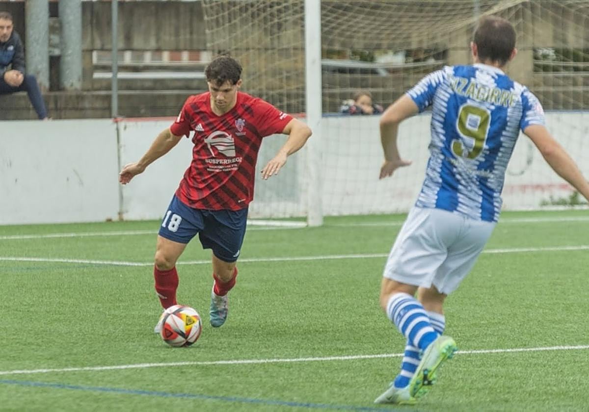 El central Iosu García despeja un balón en un partido.