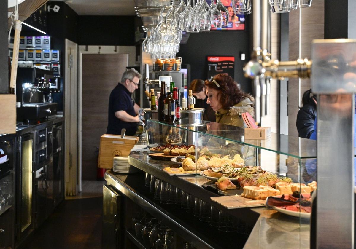 Varios clientes consumen en la barra del bar Lasarte de Lasarte-Oria.