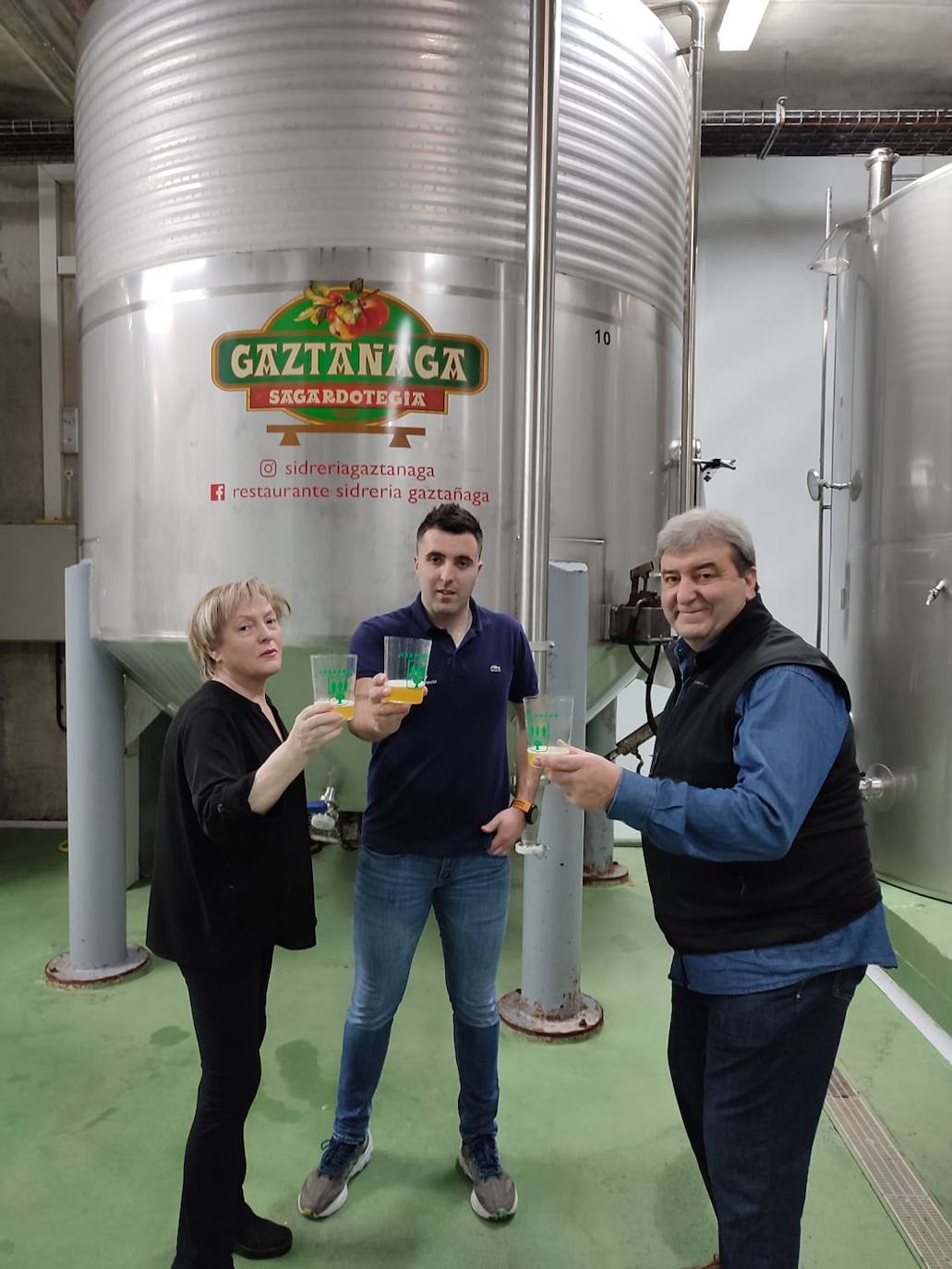 María Angeles,Axier y Ángel brindan con la nueva sidra ante las kupelas de Gaztañaga sagardotegia.