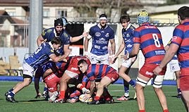 Alain Araña se dispone a enviar el oval a un compañero en un reagrupamiento ayer en Altamira ante la mirada de los jugadores pucelanos.
