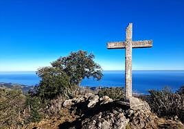 La gran encina se erige como protagonista junto a la cruz de Arno y su buzón ante un precioso Cantábrico.