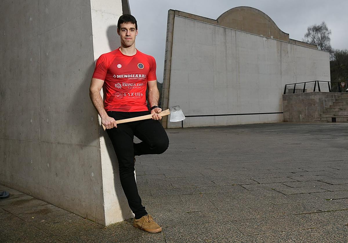 Julen Alberdi con un hacha delante del los frontones Oteiza de Azkoitia, su localidad natal.